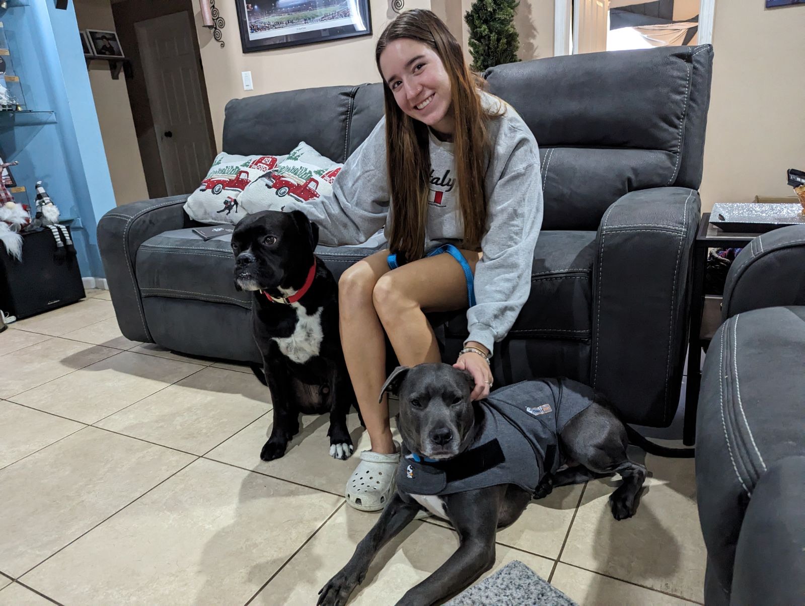 A girl with two black dogs