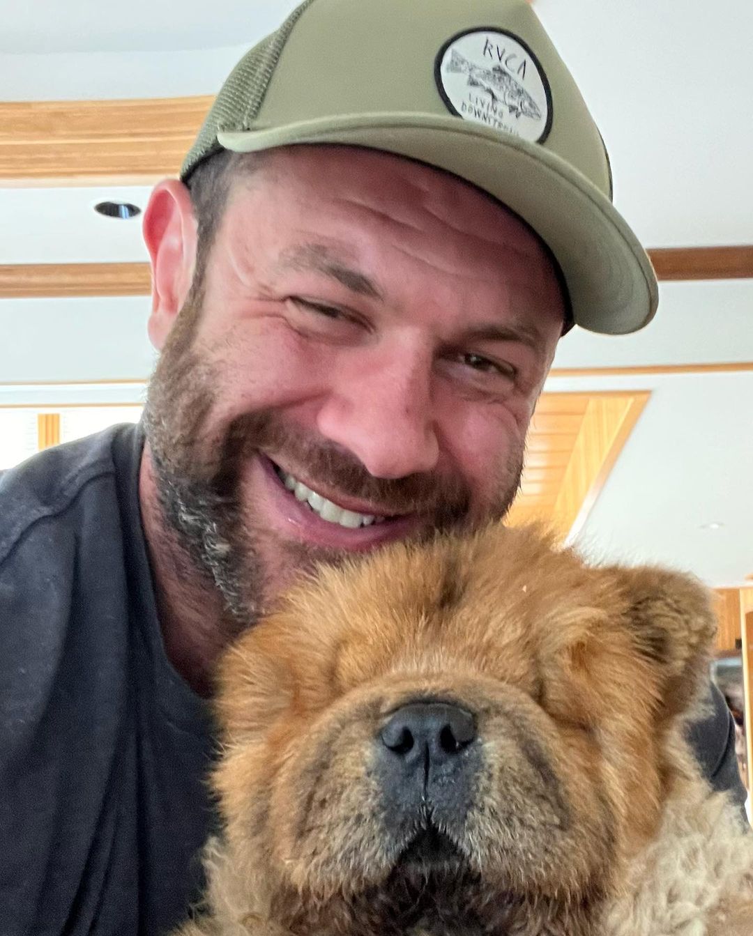 guy holding a dog that looks like a bear