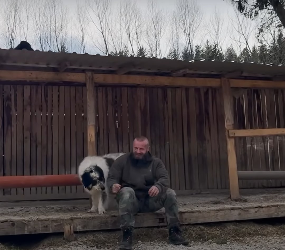 man sitting on porch with dog