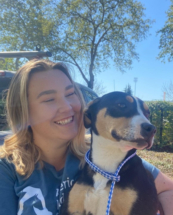 smiling girl with a dog in her arms