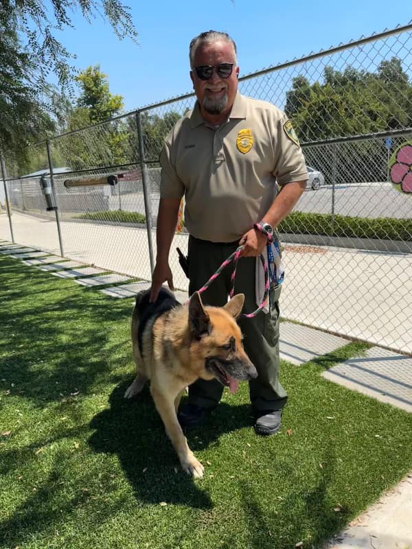 the policeman is holding the dog on a leash