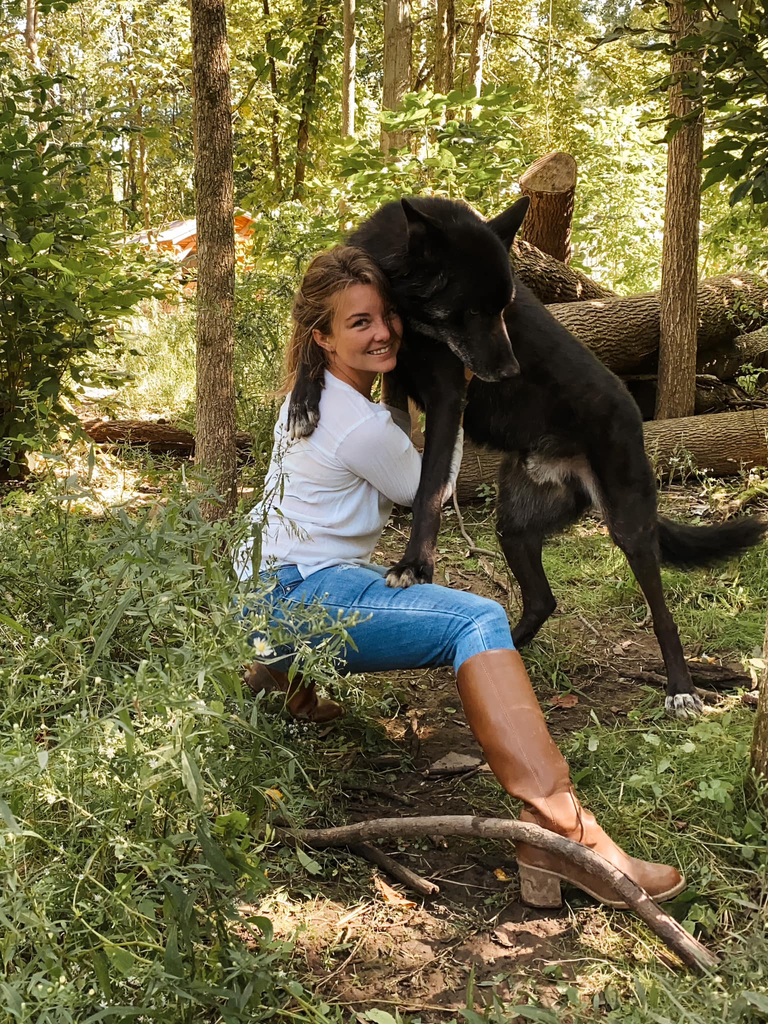 woman and wolfdog in woods