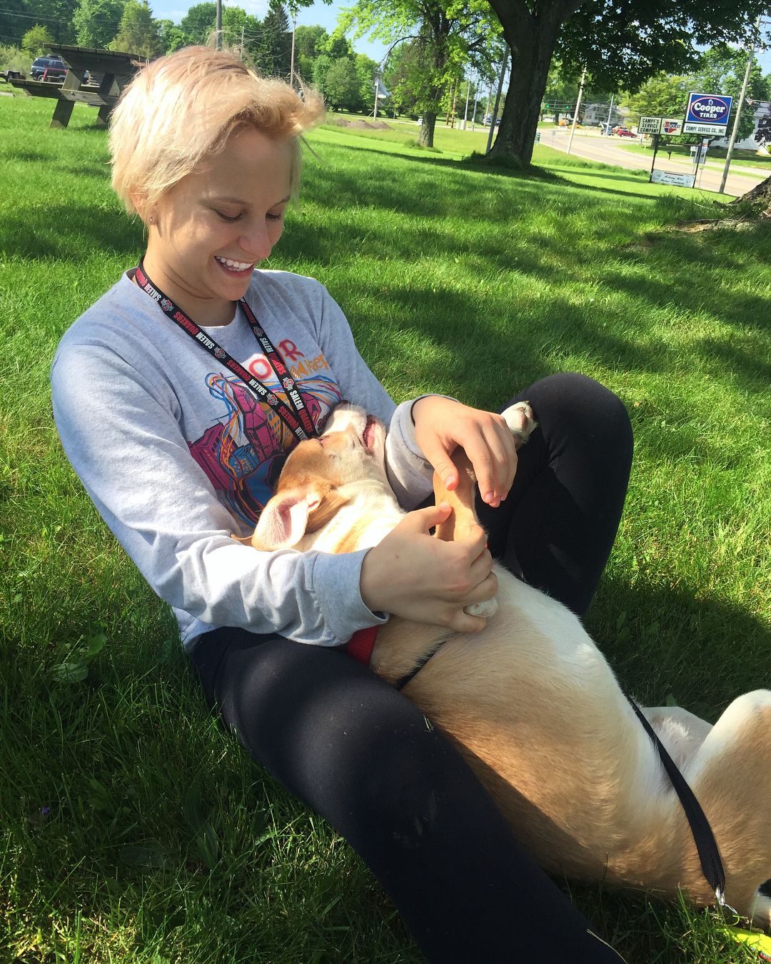 woman cuddling with dog in the park