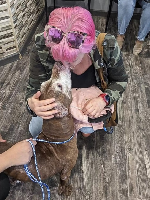 woman giving dog a kiss