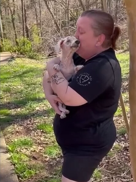 woman holding senior blind dog