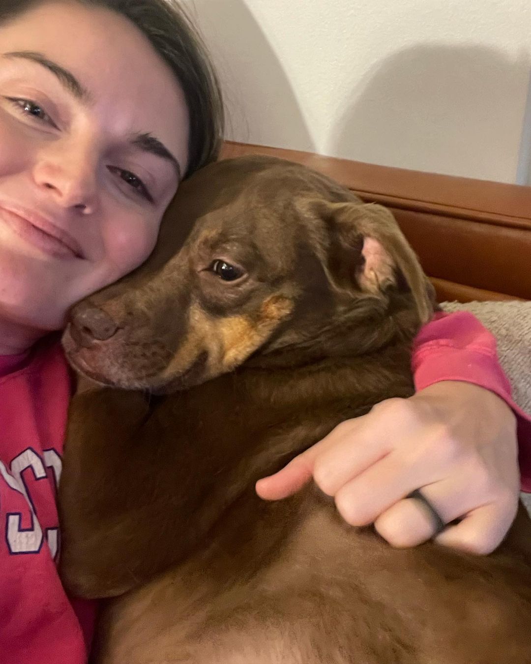 young woman with dog in hug