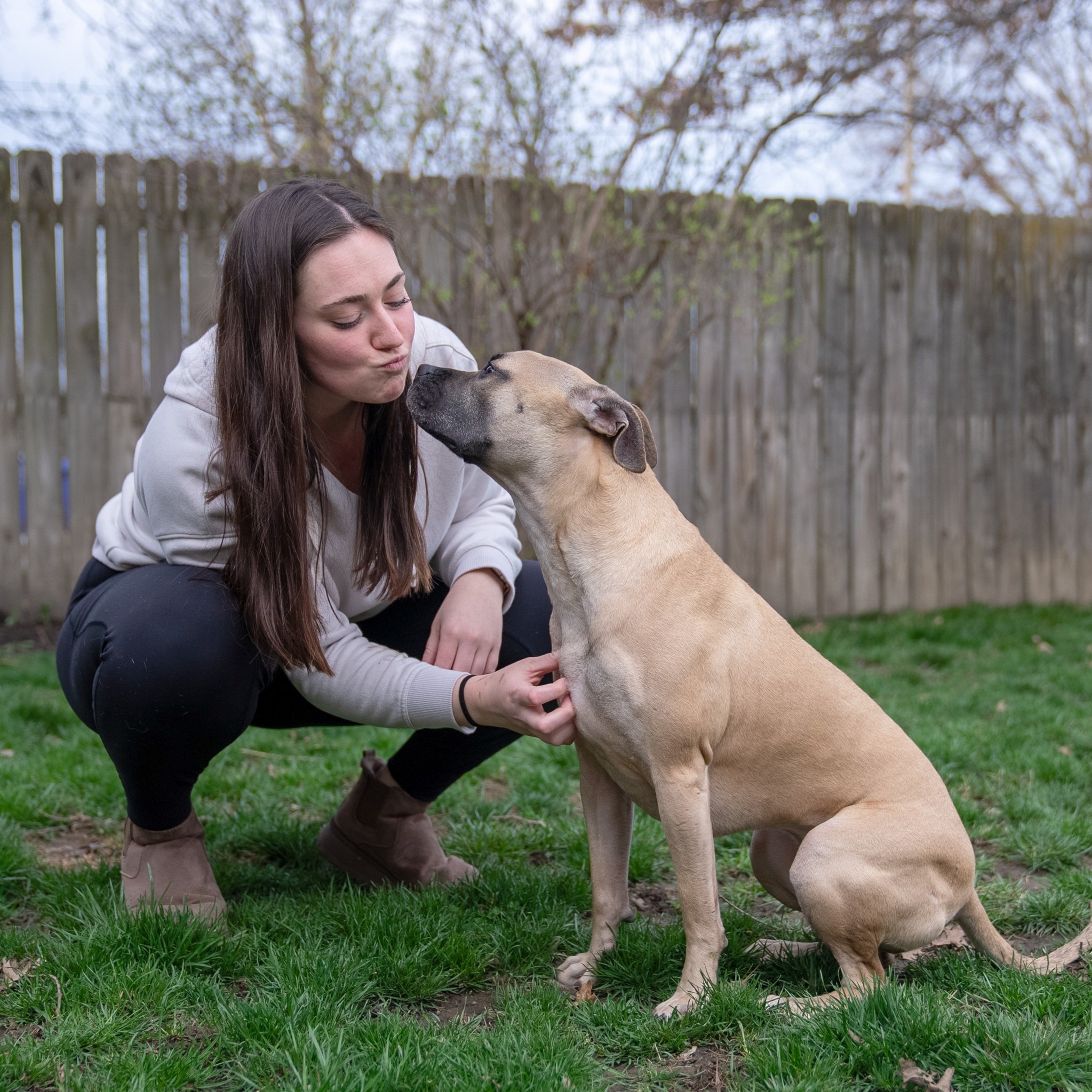 woman kissing a dog