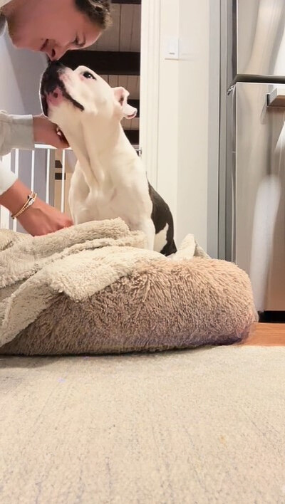 a woman cuddles with a dog before going to bed