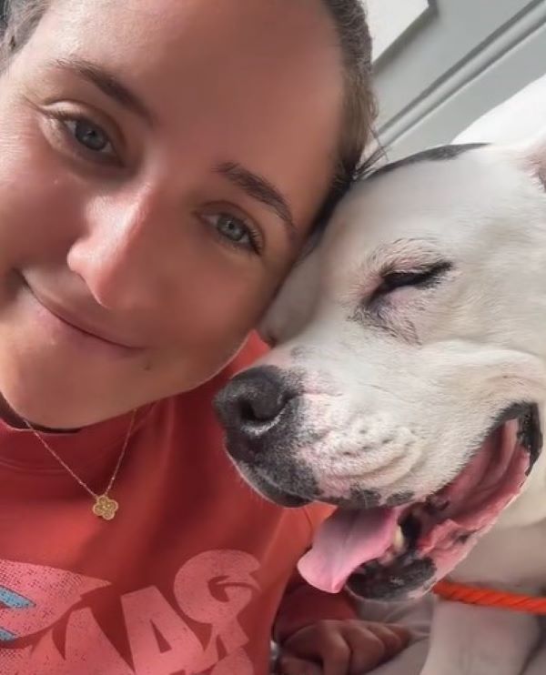 a woman takes a picture with a cute dog