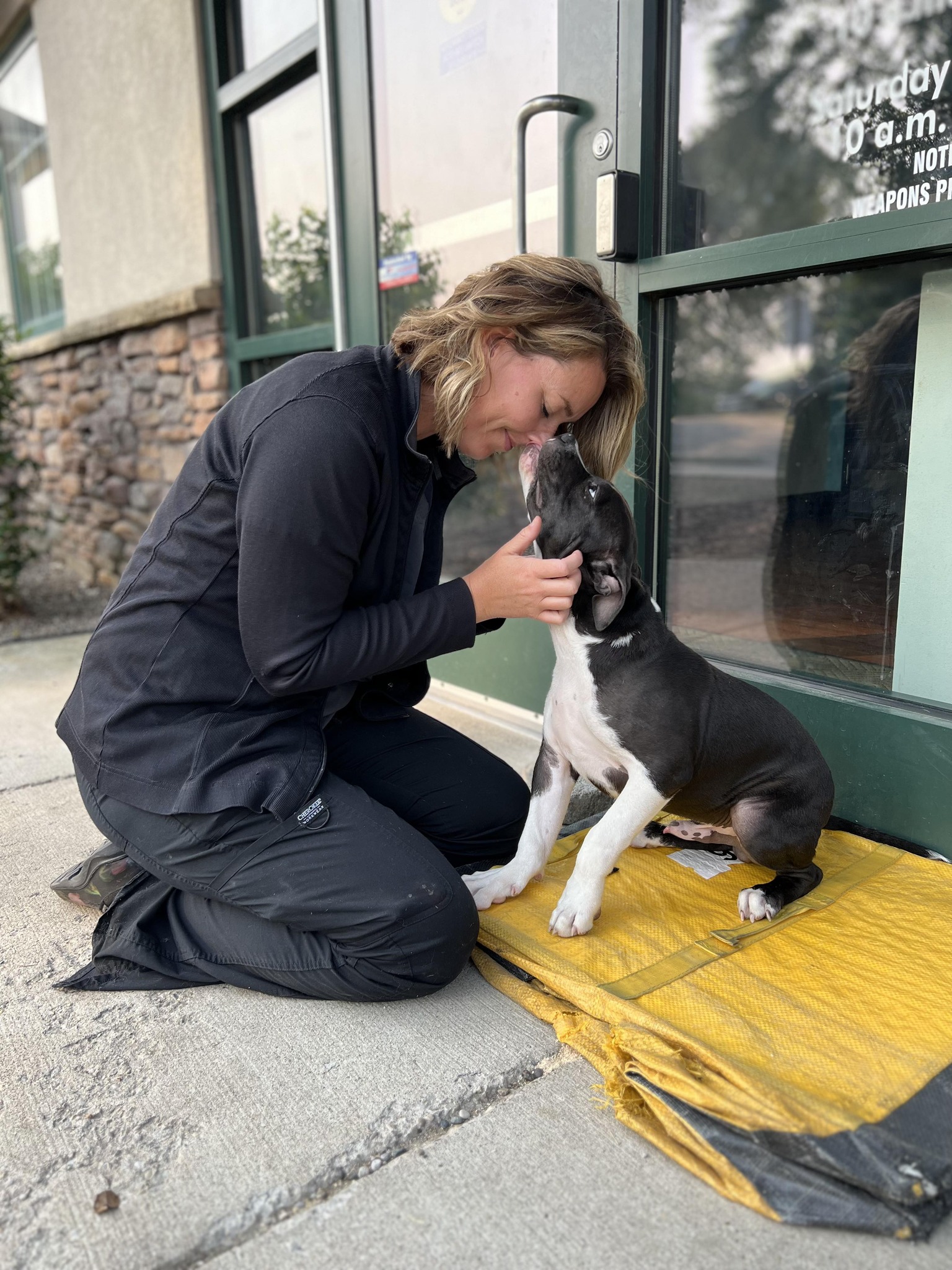 woman and the dog sitting on the sidewalk