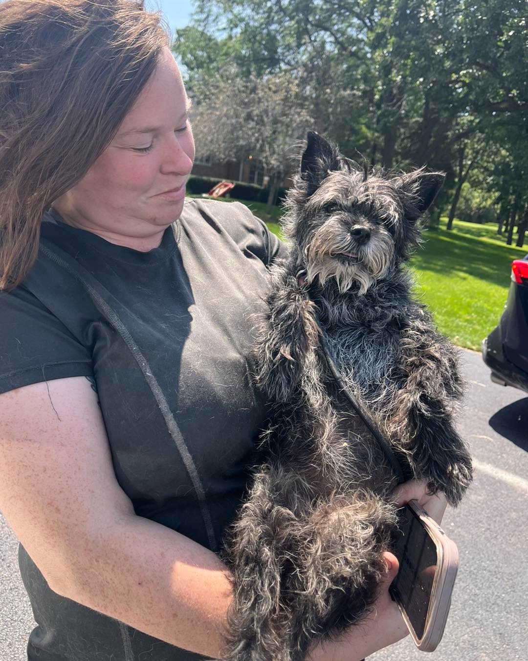 woman holding a black dog